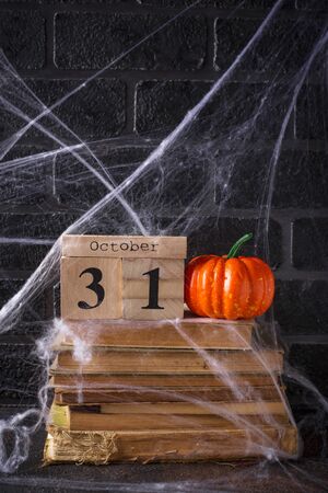 Halloween background with wooden calendar and old booksの写真素材