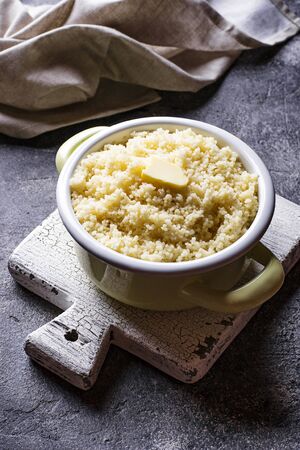 Couscous with butter in pot on dark backgroundの写真素材