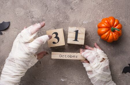 Halloween background with mummyâs hands and wooden calendarの写真素材