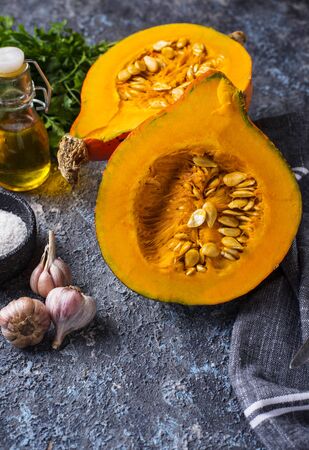 Halves of hokkaido pumpkin with spices for cookingの写真素材