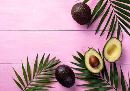 Half and whole avocado and palm leaves