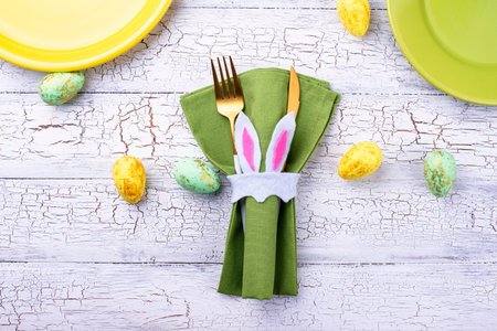 Easter table setting in green color with napkin holder in shape of bunny ears