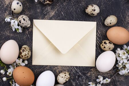 Chicken and quail eggs with blooming branch and envelope. Top viewの写真素材
