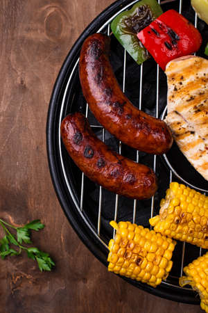 Grilled sausages, meat, and vegetables.の写真素材