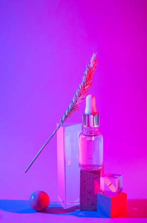Bottle of cosmetic serum in neon lightの写真素材