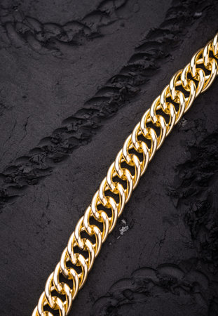 Golden chains earrings on black background.