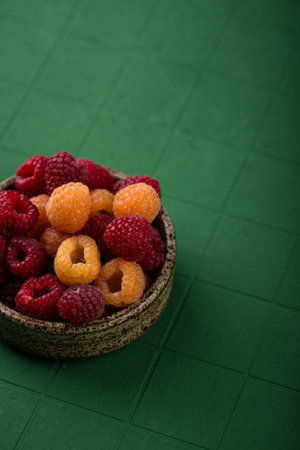 Fresh ripe raspberry on green background.