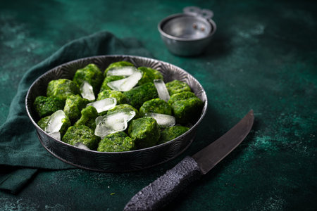 Frozen spinach green cubes in bowlの写真素材