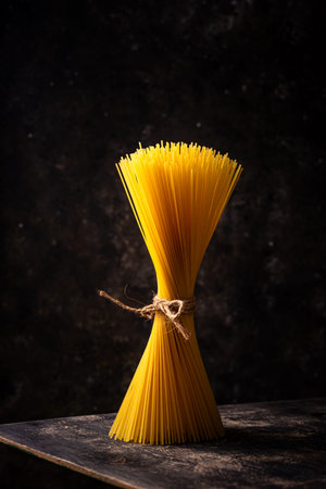 Raw uncooked sspaghetti on dark backgroundの写真素材