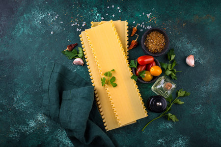 Uncooked lasagna pasta with cooking ingredientの写真素材