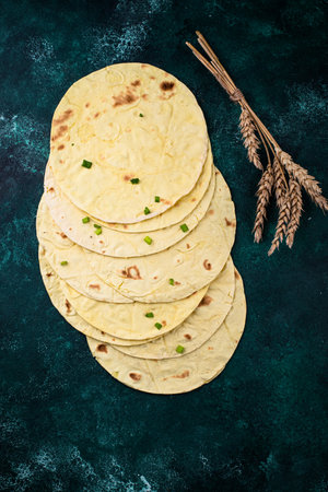 Lavash flat bread on green background