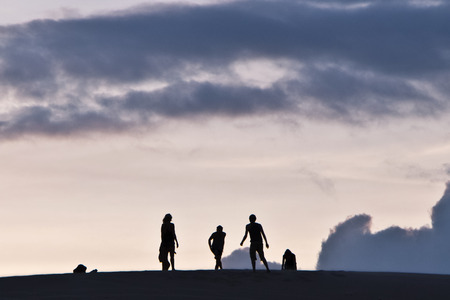 Silhouettes of people on a sky backgroundの写真素材