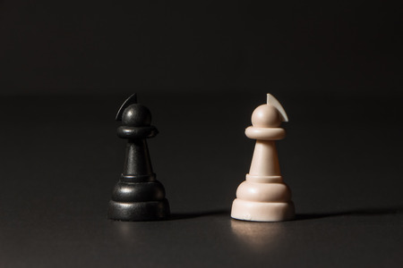 various plastic chess pieces stand on a black backgroundの写真素材