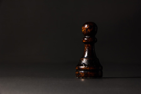 chess pieces made out of wood on a black backgroundの写真素材