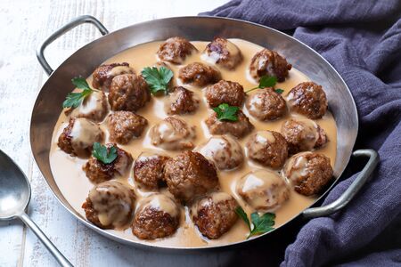 Meatballs in a pan with cream sauceの写真素材