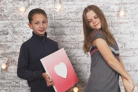 Happy Valentine's Day. Young boy giving a heart picture to his girlfriendの写真素材