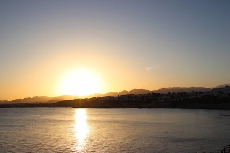 Scenic sunset in Sharm El Sheikh. The sea, mountains and giant sunset sun view. The atmosphere of relaxation and freedom. Perfect vacationの写真素材