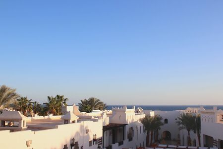 White roofs of Eastern style resort. Palm trees and sea on the horizon. Perfect vacationの写真素材