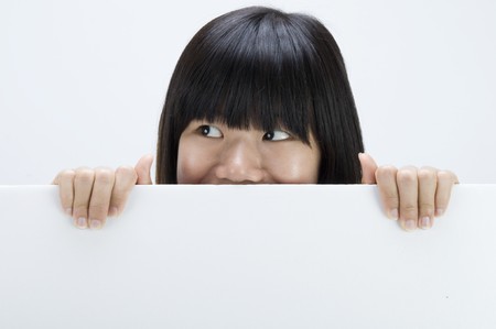 asian girl hiding with a blank card boardの写真素材