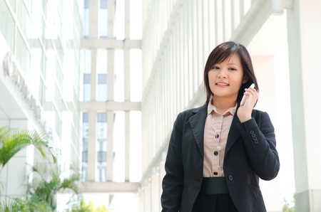 asian business girl using phone at office buildingの写真素材