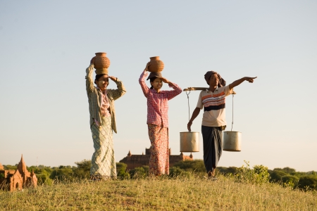 traditional asian farmer coming back from a harvest rice field in baganの写真素材