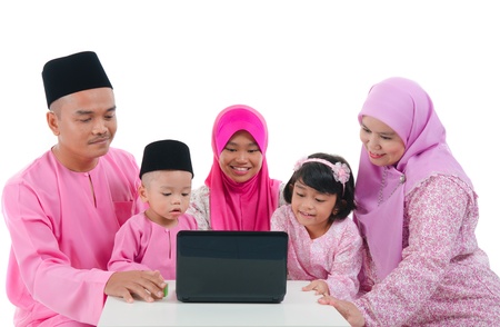 malay family with traditional maalysian traditional clothes and learning computerの写真素材