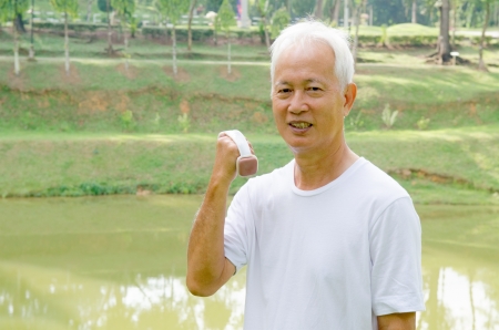 Senior man using dumbells on outdoorの写真素材