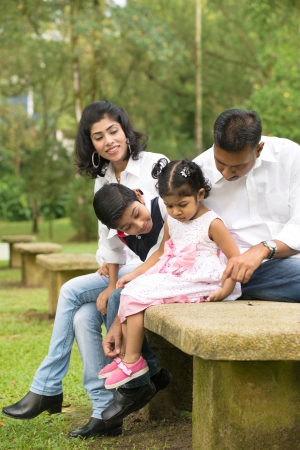 indian family sitting in the park lifestyle photoの写真素材