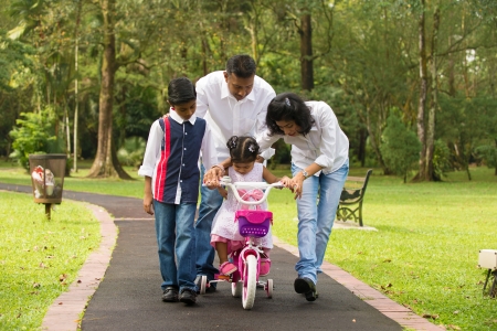 indian family guiding little daughter to cycle

の写真素材