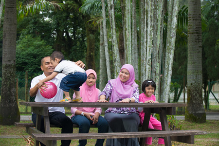 Happy Malay Asian Family enjoying family time together in the parkの写真素材