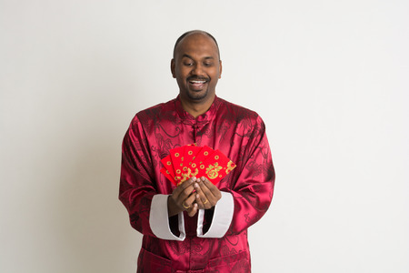 indian male with chinese new year clothes and ang paoの写真素材
