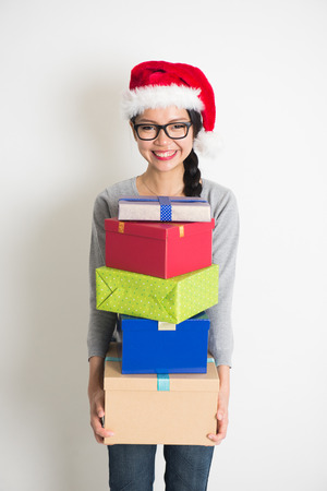 asian girl with christmas gift and santa hatの写真素材
