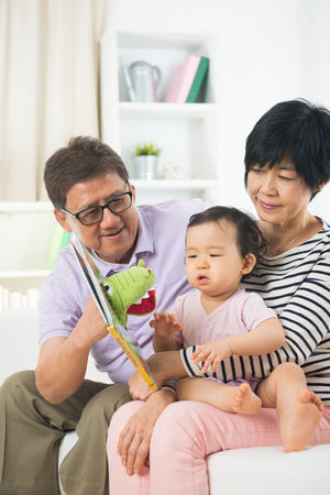asian grand parents with crying grand daugtherの写真素材