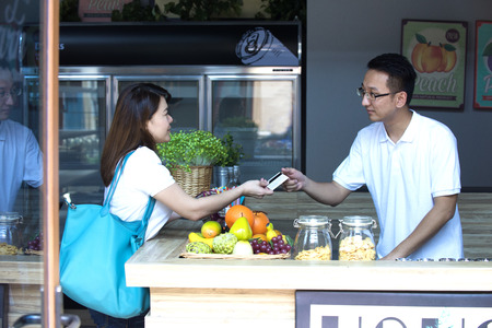 asian girl paying bills  for grocery to sales manの写真素材