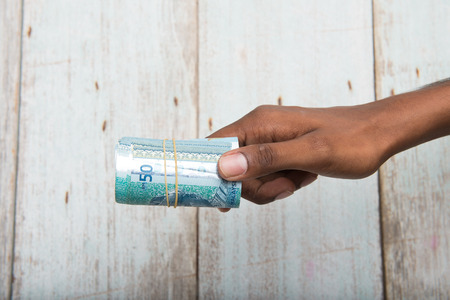 Handing out money in Malaysia ringgit , dark tone skinの写真素材