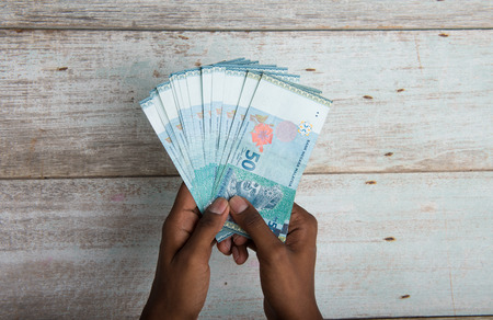 Handing out money in Malaysia ringgit , dark tone skinの写真素材