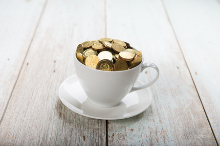 gold coins on coffee cupの写真素材