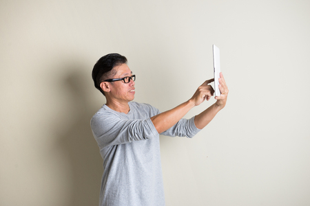 matured asian male using tabletの写真素材