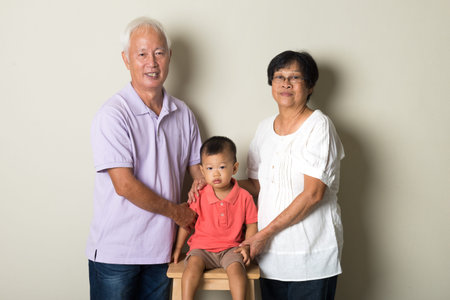 Portrait Of Chinese Grandparents With Grandson  At Home Together