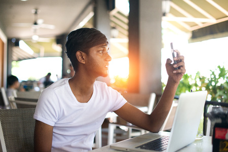teenage indian male taking selfie at cafeの写真素材