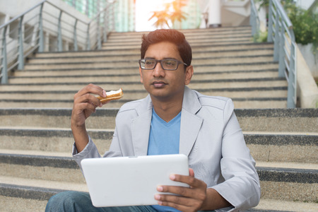 indian business male eating breadの写真素材