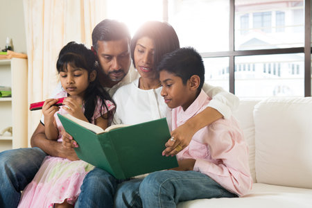 indian family reading a book togetherの写真素材