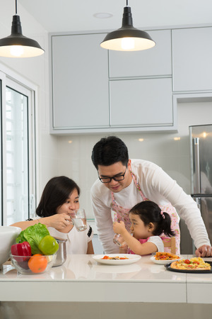 asian family enjoying and cooking pizzaの写真素材