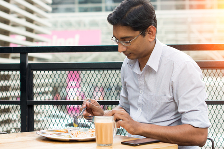 asian business man having roti canai outdoorの写真素材