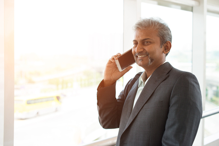 indian business male using phone at the airportの写真素材