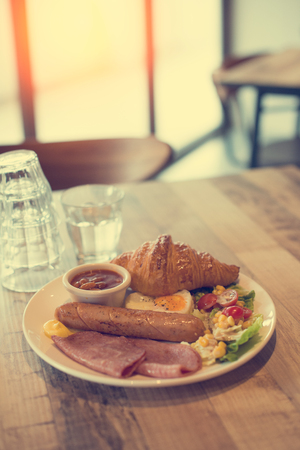 English breakfast with fried eggs, bacon, sausages, beans, toasts and fresh saladの写真素材