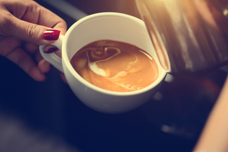 how to make latte art by barista focus in milk and coffee in vintage colorの写真素材