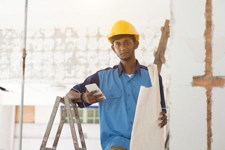 indian male construction worker using phoneの写真素材