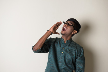 teenage indian male in traditional dress shoutingの写真素材