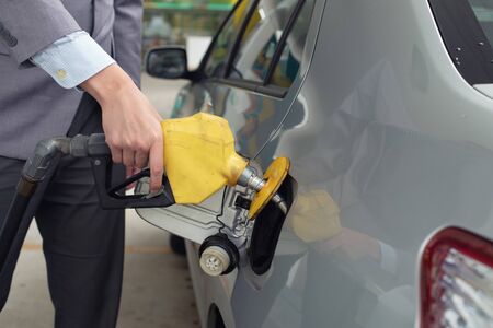 Pumping gas at gas pump. Closeup of man pumping gasoline fuel in car at gas station.

Mの写真素材